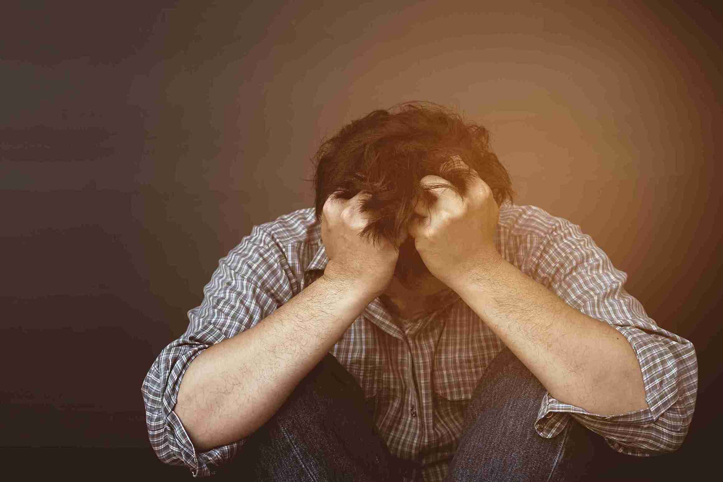 sad or depressed man holding head with hand