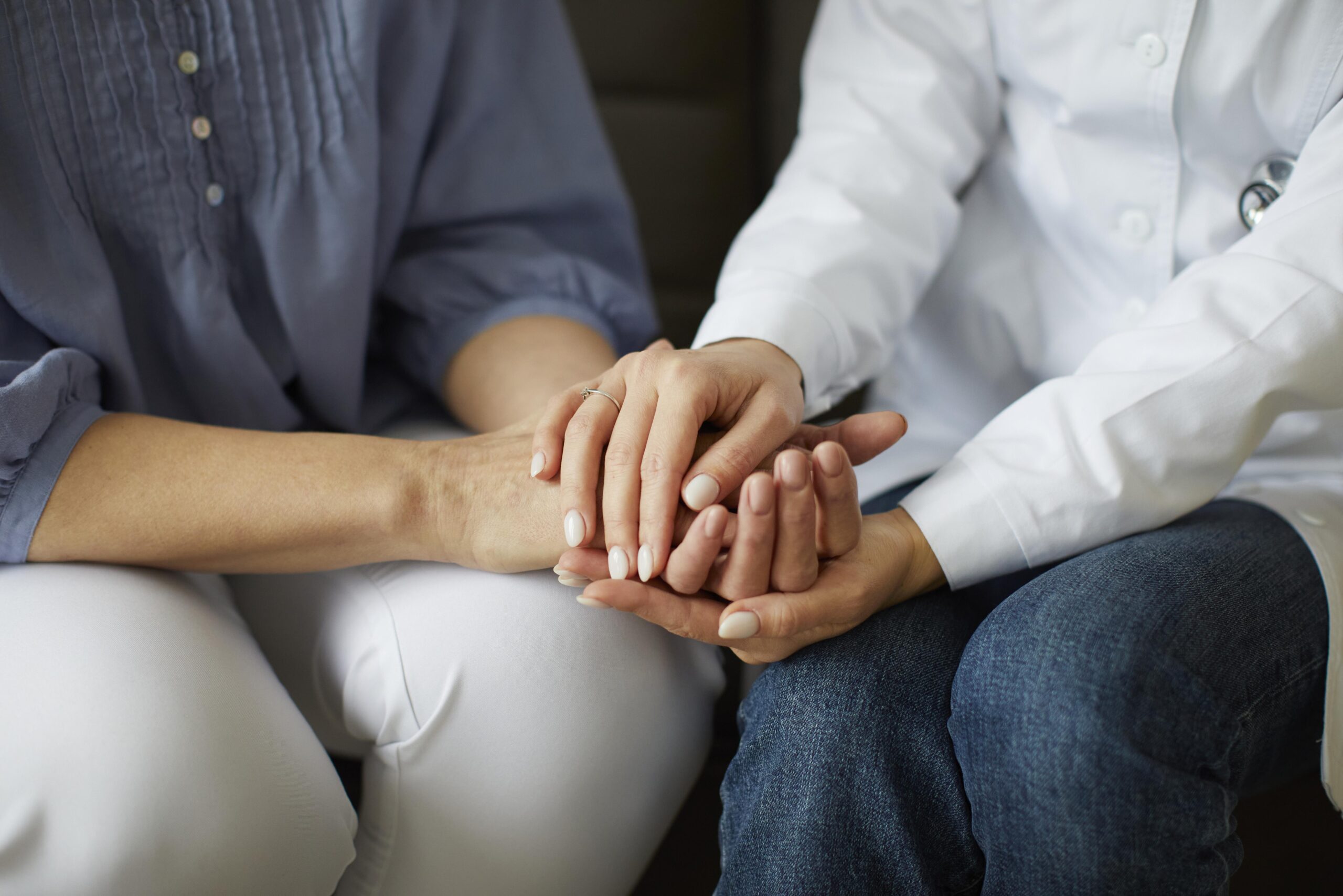 female doctor holding patient hand