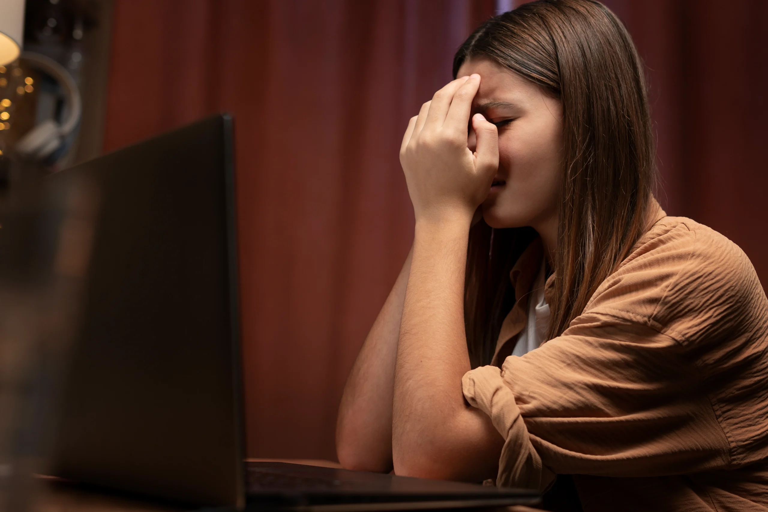 a girl with her laptop and experienced Online Harassment & Social Trauma