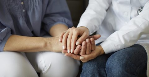 covid-recovery-center-female-doctor-holding-elder-patient-s-hands female doctor holding patient hand