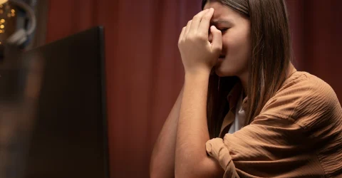 a girl with her laptop and experienced Online Harassment & Social Trauma